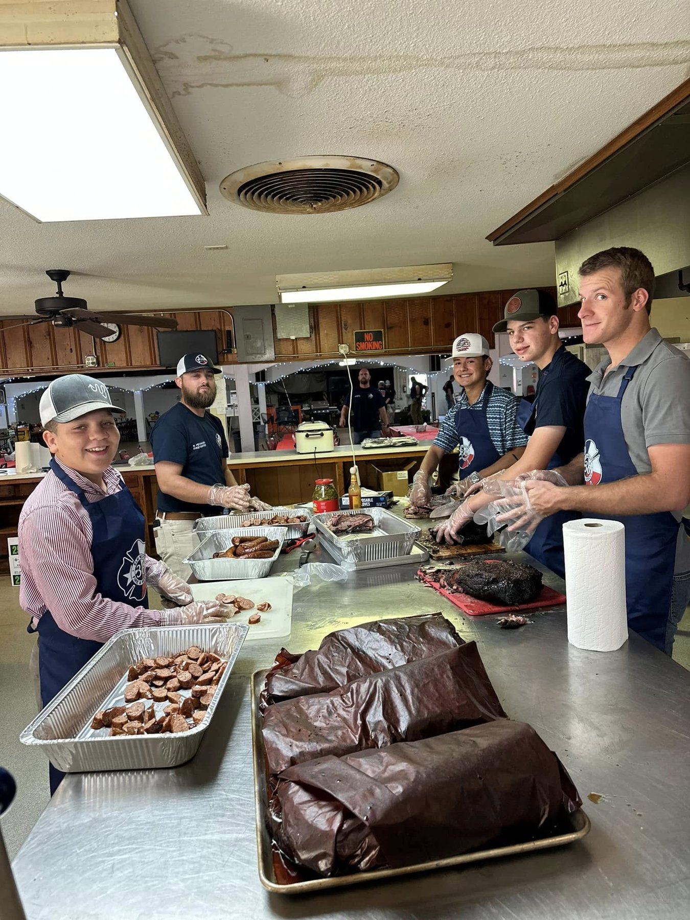 Members slicing brisket and sausage for the fundraiser